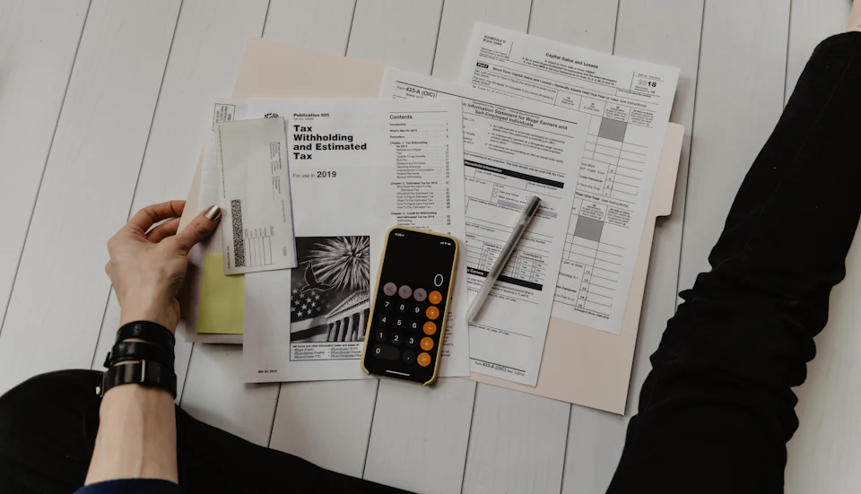 Tax documents, a calculator and financial statements on a desk